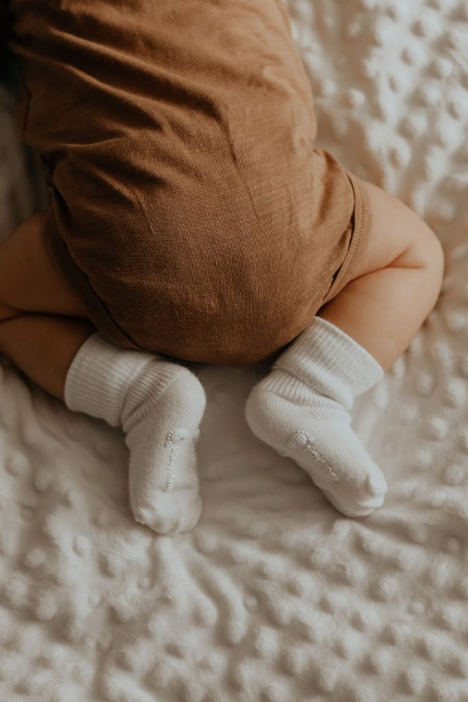 baby crawling with brown bottoms and white socks
