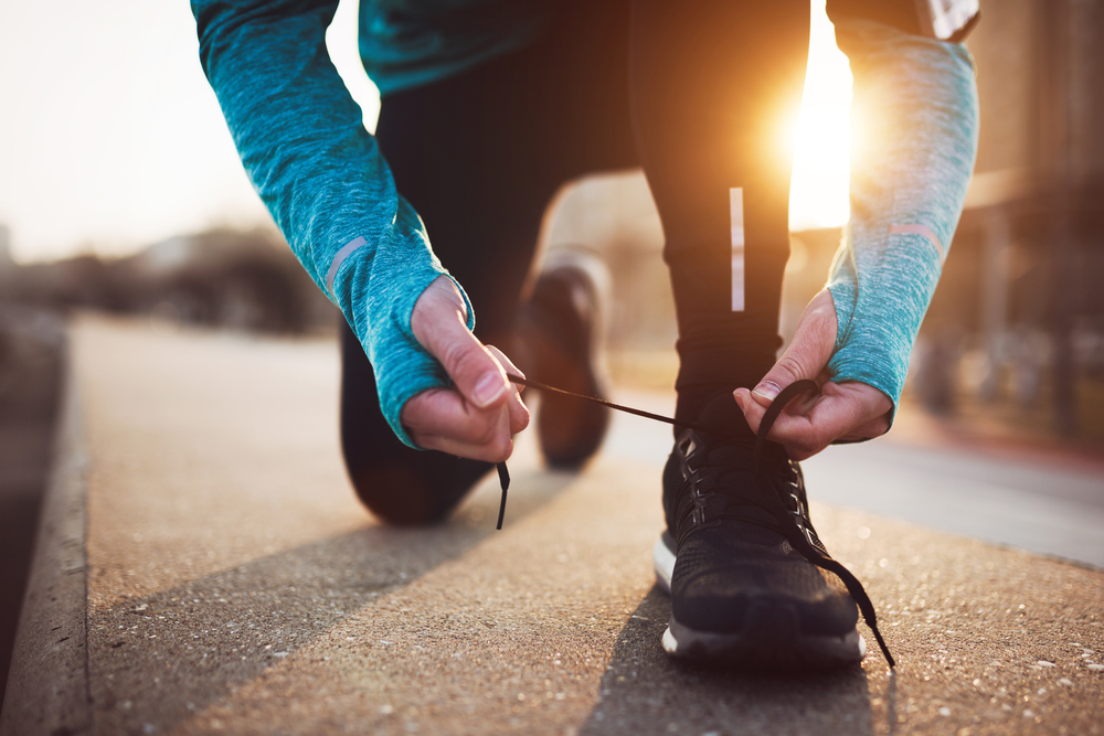 runner bending down to tie trainer laces