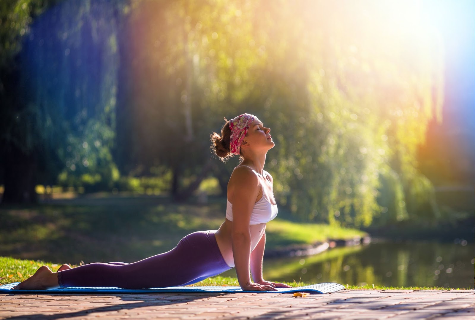 A woman doing yoga exercises outside, showing how gentle exercise and stretching can help relieve psoas muscle pain