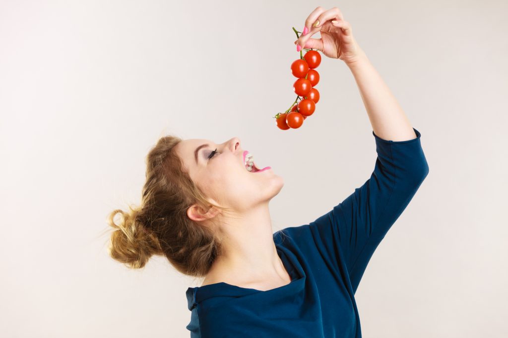 Woman Eating Vine Tomatos